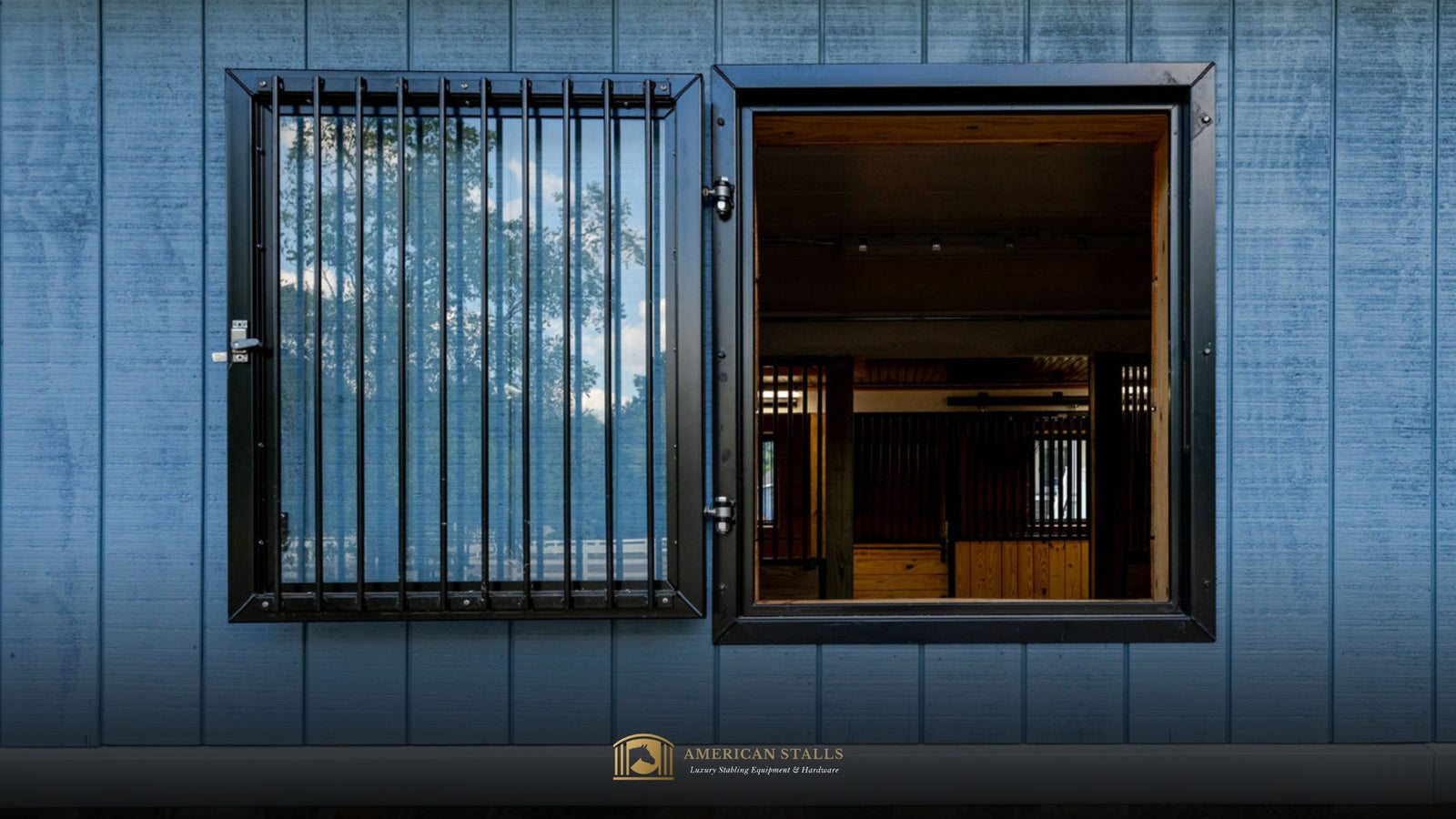 Open Dutch Window single pane glass in-fill with grill guard window on a blue barn wall with the barn interior visible.  Elegant black window steel frame.  American Stall logo visible